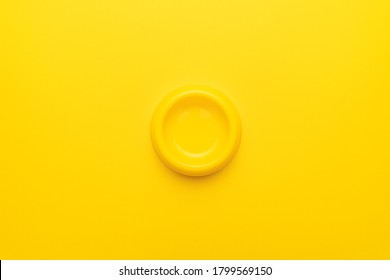 Minimalist Photo Of Yellow Pet Bowl On The Yellow Background. Overhead Image Of Empty Cat Bowl.
