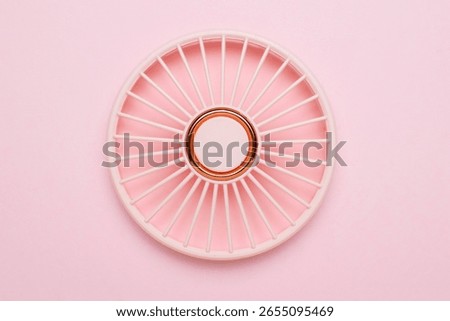 Minimalist Pink and White Circular Patterned Object on Pastel Background