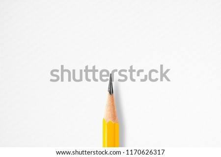Minimalist presentation template with copy space by top view close up macro photo of wooden yellow pencil isolated in center of white textured paper. Flash light made smooth shadow from pencil.