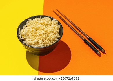 Minimalist Ramen Noodles in Black Bowl with Chopsticks on Vibrant Split Background - Powered by Shutterstock