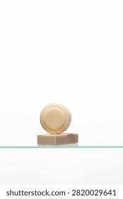 A minimalist stack of two artisanal soap bars-one round, one rectangular-showcasing natural, uncolored tones. Represents a simple, gentle skincare and personal hygiene routine.