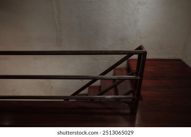 A minimalist staircase with dark wooden steps and a sleek metal railing against a textured, beige plaster wall. - Powered by Shutterstock