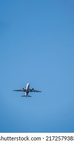 Minimalist terrestrial view of the underside of a commerical jet airliner in mid air on a sunny afternoon over Washington DC