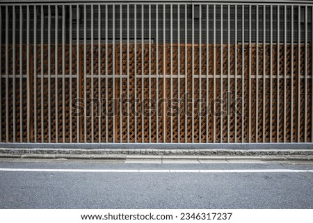 Minimalist urban background with negative space as copy space. Frontal view of a tall metal trellis on a side street.