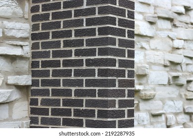 Minimalist View Of A Brick Column Set Against A Stone Wall.