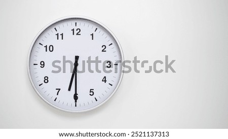 Minimalist White Clock with Silver Frame Striking 18.30 or 06.30 on White Background – Perfect for Time Management and Corporate Campaigns