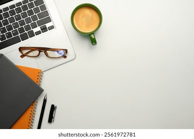 Minimalist workspace with a laptop, glasses, notebooks and a cup of coffee on clean white surface - Powered by Shutterstock