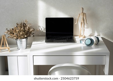 Minimalist workspace with laptop, headphones and decor on white desk. - Powered by Shutterstock