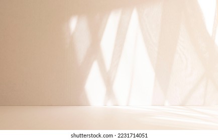 Minimalistic abstract gentle light beige background for product presentation with light and shadow of window curtains on wall.