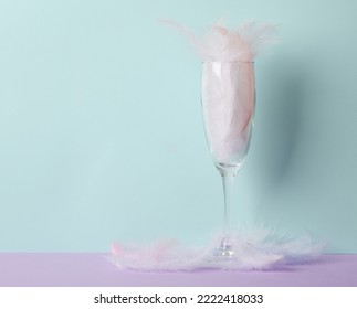 Minimalistic Aesthetic Still Life. Glass With Feathers On A Pastel Two Tone Background. Party Concept