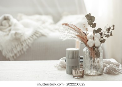 A minimalistic composition in the Scandinavian style with dried flowers in a vase and candles. - Powered by Shutterstock