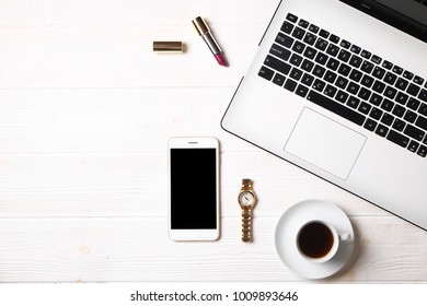 Minimalistic flat lay composition, black & white laptop computer keyboard, cell phone gadget, coffee cup, wrist watch & lipstick on textured wooden desk table background. Top view, copy text space.