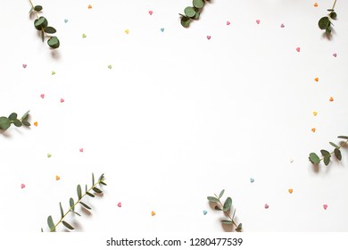 Minimalistic frame with leaves and little hearts on the white paper background. Top view. Copy space - Shutterstock ID 1280477539