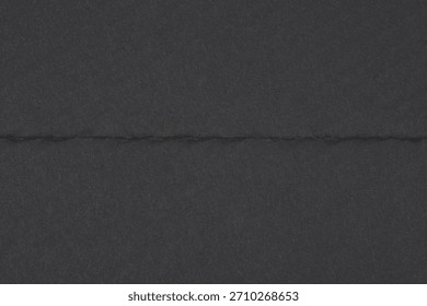 A minimalistic, horizontal image featuring a sharp, distinct horizontal fold or crease dividing a dark gray to black textured paper background