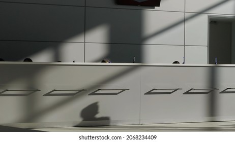 Minimalistic interior of a hotel lobby with the reception desk. HDR. Concept of architecture and design, grey reception desk and a wall with a minimum of details.