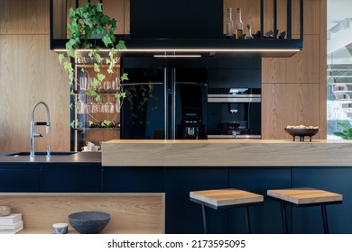 Minimalistic modern wooden panel kitchen interior with ergonomic biuld-in kitchen and kitchen island. Geometric forms and shapes. Details. Template. 
 - Powered by Shutterstock