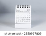 Minimalistic photo of a desk calendar displaying March 2025. Clean and professional design, suitable for topics like planning, organization, and productivity.