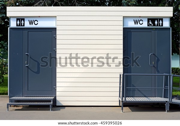 minimalistic simple portable toilet cabin with disabled\
access ramp and information billboard side detail exterior view\
