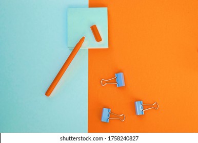 Minimum Set Of School And Office Supplies On Bright Blue (turquoise) And Orange Background: Pen, Clips, Note Paper. Concept: Back To School. Flatlay, Top View.