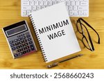 Minimum wage text on note pad with calculator.