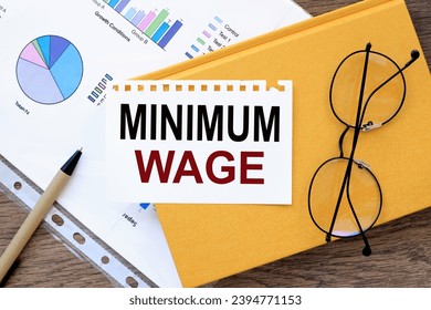 Minimum Wage. text on the page on a yellow notepad. - Shutterstock ID 2394771153