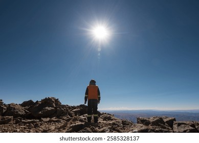 Mining construction worker on mountain top of the cerro chorolque volcano with a beautiful panoramic view of a desert and arid space