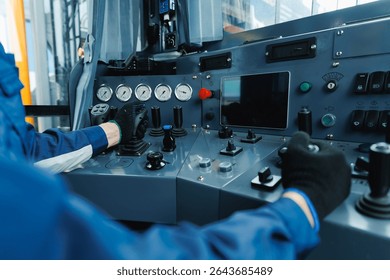 Mining equipment control panel with operator using levers and buttons in industrial setting.