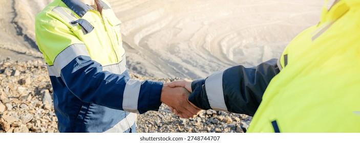 Mining Industry Agreement, Two Engineers Shaking Hands at Open-Pit Mine of ore.