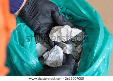 Mining of lithium. Sample of spodumene hard rock ore, examined by mine geologist. Processed into spodumene concentrate 6 or SC6, for subsequent production of lithium-ion batteries