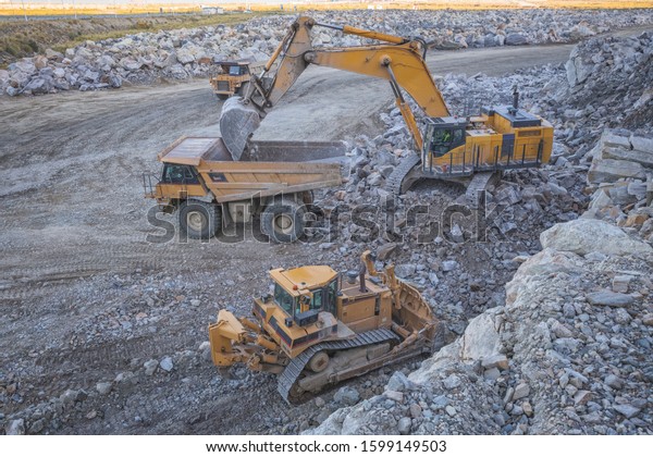 Mining machinery working\
over rocks.