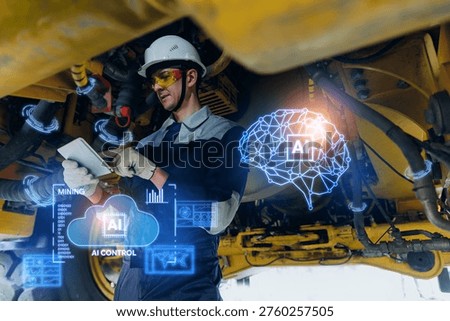 Mining technician using tablet under heavy truck with ai assistant brain hologram for industrial diagnostics of hydraulics system hoses.