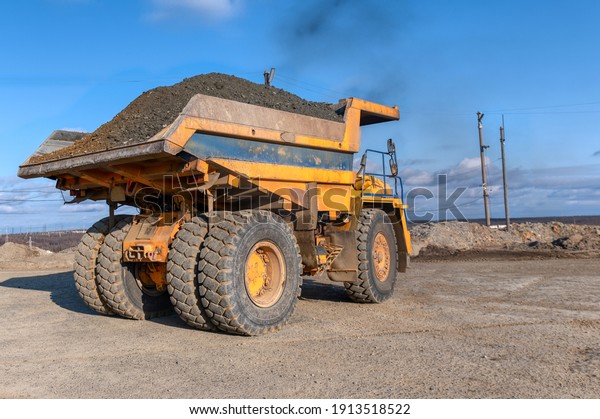 Mining truck dump truck\
loaded with ore. Transportation of mined ore from the open pit to\
the surface.
