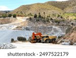 Mining truck in open-pit mining. Excavator and Haul truck on lithium miningcivil works and Earthmoving. Off highway Trucks in Limestone quarry. Haul dump truck in Spain mountains. Chalk and Dolomite.