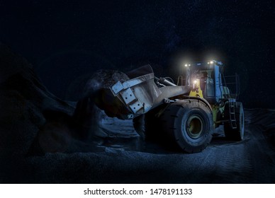 Mining wheel loader Scooping Gravel on a night time construction project