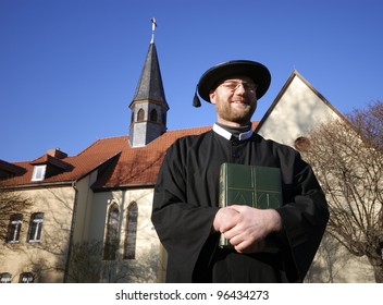 Minister With Bible In Front Of Church