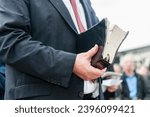 Minister holding a large, well used bible