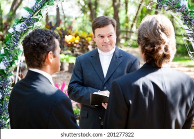 Minister performing marriage ceremony for two grooms at a gay wedding.   - Powered by Shutterstock