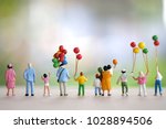 Miniture family with balloon  standing and looking forward use as happy background.