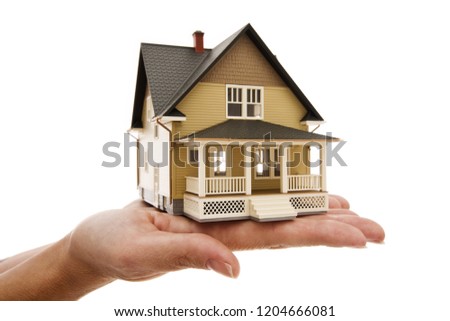 Miniture house sitting in a hand