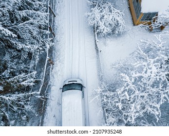 A Minivan Driving On Empty Street, Covered With Snow, Aerial View