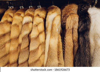 Mink coats of different colors in a shop on a hanger.