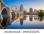 Minneapolis, Minnesota, USA downtown skyline on the Mississippi River with the Third Avenue Bridge at twilight.