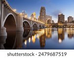 Minneapolis, Minnesota, USA downtown skyline on the Mississippi River with the Third Avenue Bridge at twilight.