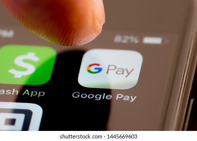MINNEAPOLIS, MINNESOTA / USA - JULY 7, 2019: Person Using Apple I-phone To Press And Access The Google Pay App /  Application