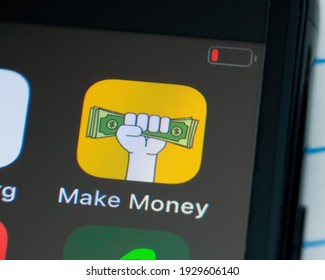 MINNEAPOLIS, MINNESOTA - USA - MARCH 4, 2021: Person Using Apple I-phone To Press And Access The Make Money Logo App - Application