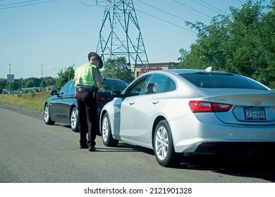 MINNEAPOLIS, MINNESOTA USA - SEPTEMBER 19, 2019: Highway Patrol Officer Giving A Ticket To A Driver.