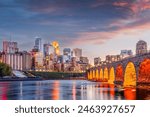 Minneapolis, Minnesota, USA skyline with the Stone Arch Bridge on the Mississippi River at dusk.