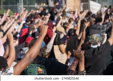 Minneapolis, Minnesota/United States of America - May 30, 2020: Protestors raise their hands in solidarity outside of the Fifth Police Precinct in Minneapolis in response to the death of George Floyd.