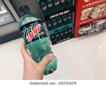 Minneapolis, MN - April 2, 2019: Caucasian Woman Shopper's Hand Holds A Bottle Of Mountain Dew Baja Blast Flavor, A Limited Edition Soda Pop From Coca Cola Brands