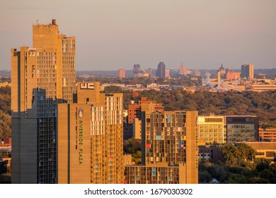 MINNEAPOLIS, MN - OCTOBER 2018 - A Telephoto Shot Of The Riverside Plaza And Distant St. Paul Skyline Under Golden Sunset Light